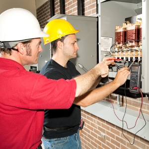 Workers testing electrical panel